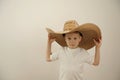 little boy 5 cowboy hat big hat fits over eyes he straightens it t-shirt is isolated white background he smiles Royalty Free Stock Photo