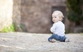 Little boy crawling on stone paved sidewalk