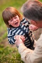 Boy crying hard, eyes shot full of tears, holding hands of grand