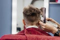 Close-up of woman hands grooming kid boy hair in barber shop Royalty Free Stock Photo