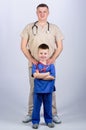 Little boy with dad in hospital. father and son in medical uniform. happy child with father with stethoscope. family
