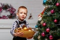 Little boy decorates a Christmas tree in the interior with Chris Royalty Free Stock Photo