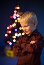 Little boy decorates the Christmas tree. Spruce with decorations. Kid and adornment Royalty Free Stock Photo