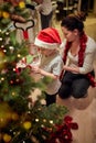A little boy decorating a Christmas tree with his mother at home. Together, New Year, family, celebration Royalty Free Stock Photo
