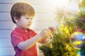Little boy decorating Christmas tree with toy balls Royalty Free Stock Photo