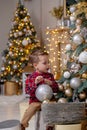 Little boy decorating Christmas tree with toy balls Royalty Free Stock Photo