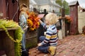 Little boy decorating by dried leafs porch and front door of his house for halloween on the street of New York Royalty Free Stock Photo