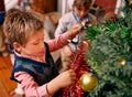 Little boy, decorating and tree for Christmas with ornaments, lights and celebration for season in season. Child Royalty Free Stock Photo