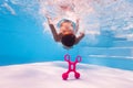 Little boy dive deep to reach a toy on pool bottom