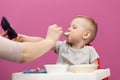 Little boy does not want to eat Mashed potatoes. Child eats breakfast at home, while watching cartoon on tablet Royalty Free Stock Photo