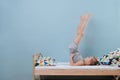 Little boy doing candlestick exercise. Time for morning gymnastics in unmade bed Royalty Free Stock Photo