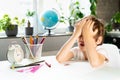 Little boy doing homework at home at the table, overwork of a first-grader from studying, stress of a schoolboy Royalty Free Stock Photo