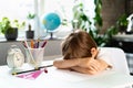 Little boy doing homework at home at the table, overwork of a first-grader from studying, stress of a schoolboy Royalty Free Stock Photo