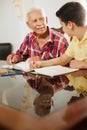 Little Boy Doing School Homework With Old Man At Home Royalty Free Stock Photo