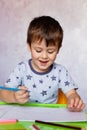 Little boy drawing with color pencils. Boy, drawing a picture for fathers day. Small boy draws at the table Royalty Free Stock Photo