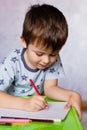 Little boy drawing with color pencils. Boy, drawing a picture for fathers day. Small boy draws at the table Royalty Free Stock Photo