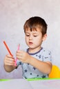 Little boy is holding color pencils. Boy, drawing a picture for fathers day. Small boy draws at the table Royalty Free Stock Photo