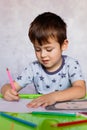 Little boy drawing with color pencils. Boy, drawing a picture for fathers day. Small boy draws at the table Royalty Free Stock Photo