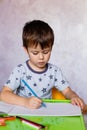 Little boy drawing with color pencils. Boy, drawing a picture for fathers day. Small boy draws at the table Royalty Free Stock Photo