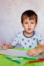 Little boy drawing with color pencils. Boy, drawing a picture for fathers day. Small boy draws at the table Royalty Free Stock Photo