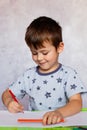 Little boy drawing with color pencils. Boy, drawing a picture for fathers day. Small boy draws at the table Royalty Free Stock Photo