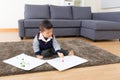 Little boy drawing picture and seating on carpet Royalty Free Stock Photo