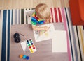 Little boy drawing picture by using watercolors and couache indoors. Royalty Free Stock Photo