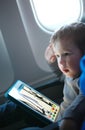 Little boy drawing on a tablet in an airplane Royalty Free Stock Photo