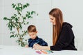 Little boy draws markers from lesson mother