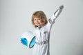 A little boy dreams of becoming an astronaut and flying into space. Cosmos childrens holding helmet in spacesuit and Royalty Free Stock Photo