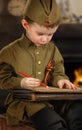 The little boy in the old-fashioned Soviet military uniform writ