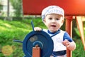 Little boy dressed up as a sailor holding the steering wheel Royalty Free Stock Photo