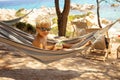 Little boy, drinking cocktail, orange juice on the beack in hammock, enjoying summer Chalkidiki, Greece Royalty Free Stock Photo