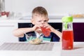 Little boy drinking fruit juice in a kitchen Royalty Free Stock Photo