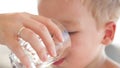 Little boy drinkng a glass of fresh water