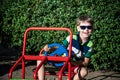 Little boy driving big toy car and having fun, outdoors