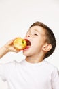 Little boy is eating apple studio shot Royalty Free Stock Photo