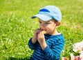 Little boy eating biscuit on lawn Royalty Free Stock Photo