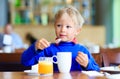 Little boy eating breakfast in cafe Royalty Free Stock Photo