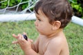 Little boy eating grape on grass