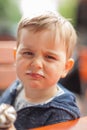 Little boy eating an ice outside in the park at a table