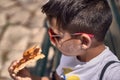 Little boy eating pizza in the street Royalty Free Stock Photo