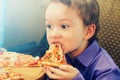 Little boy eating pizza at cafe Royalty Free Stock Photo