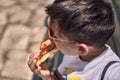 Little boy eating pizza in the street Royalty Free Stock Photo