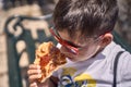 Little boy eating pizza in the street Royalty Free Stock Photo