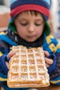 Little boy eating sweet waffle