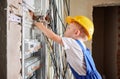 Child repairing electric panel at home during renovation. Royalty Free Stock Photo