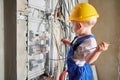 Child repairing electric panel in apartment under renovation. Royalty Free Stock Photo