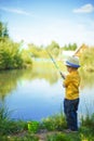 Little boy is engaged in fishing in a pond. Child with a dairy i Royalty Free Stock Photo