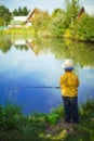 Little boy is engaged in fishing in a pond. Child with a dairy i Royalty Free Stock Photo